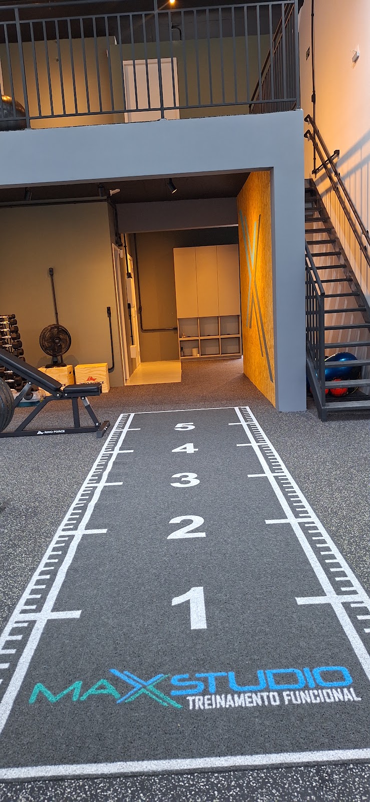 Corredor interno do Max Studio Treinamento Funcional, com marcações de treino no piso